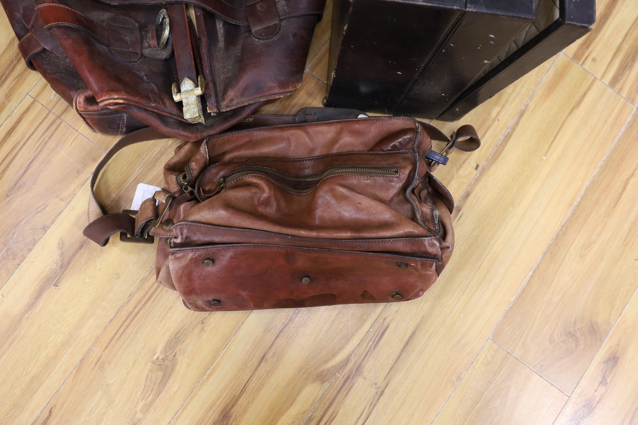 A large brown leather Gladstone bag, a Bally Italian brown leather satchel bag and a compatmental suitcase